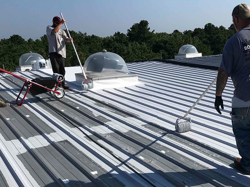 Image of Roof Restoration Crew Applying AP-3100 Acrylic Base Coating with Rollers.