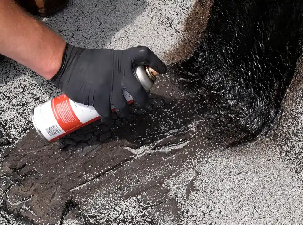 Priming a Roof Membrane at Wall Transistion with Del-Val 100 Asphalt Spray Primer